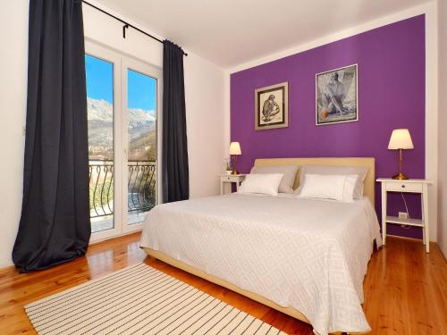 a bedroom with a large bed and a purple wall at Holiday Home Žrnovnica in Žrnovnica