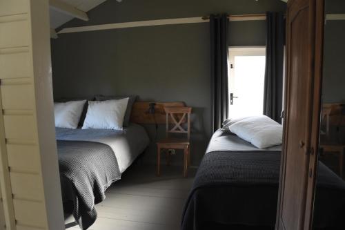 1 dormitorio con 2 camas y ventana en Buitenuit, en Boxtel