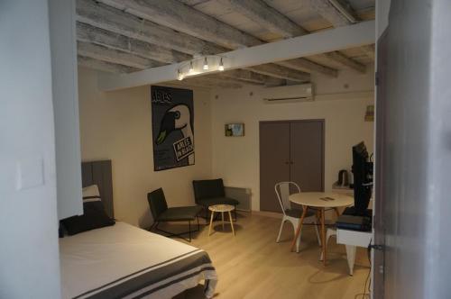 a room with a bed and a table and chairs at Studio typique et cosy climatise. in Arles