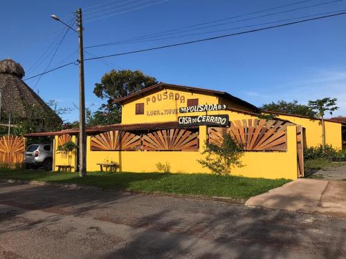 a yellow building with a sign on the side of it at Pousada Casa do Cerrado - Alto Paraíso de Goiás in Alto Paraíso de Goiás