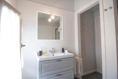 La salle de bains est pourvue d'un lavabo blanc et d'un miroir. dans l'établissement Forte 51, à Forte dei Marmi