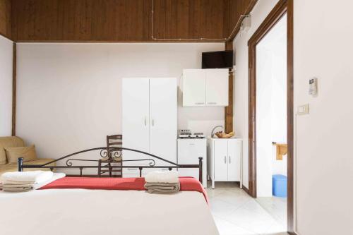 a bedroom with a bed and a small kitchen at Eloka in Torre Squillace