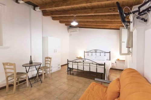 a bedroom with a bed and a table and chairs at Eloka in Torre Squillace