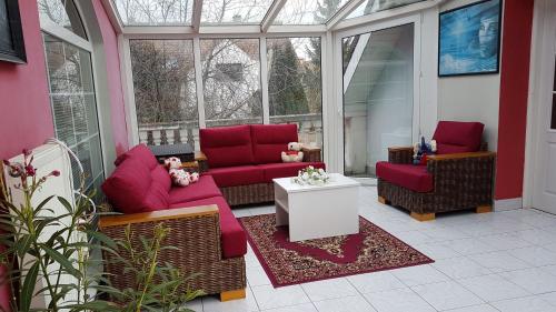eine abgeschirmte Veranda mit roten Sofas und einem Tisch in der Unterkunft Homestay Kuchařovice in Kuchařovice