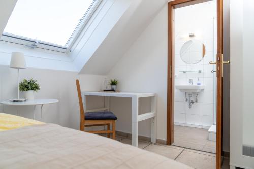 a bedroom with a bed and a sink and a bathroom at Hotel am Wasserschloss Glücksburg in Glücksburg