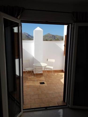 a room with a table and chairs through a sliding glass door at SEA ONE. in Port de Pollensa
