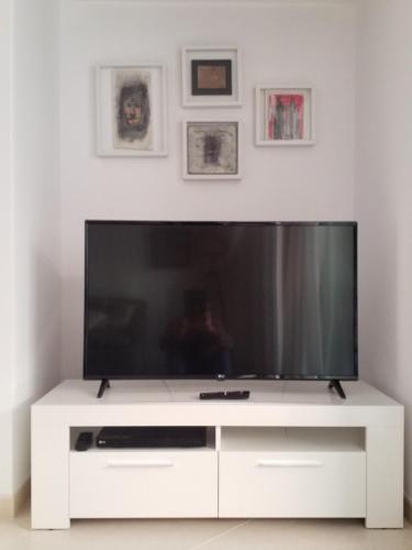 a white entertainment center with a large screen television at SEA ONE. in Port de Pollensa