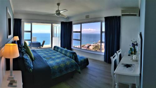 a bedroom with a bed and a view of the ocean at Penguinden - load-shedding free in Simonʼs Town