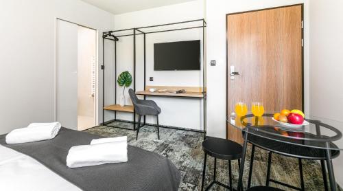 um quarto com uma cama, uma mesa e uma secretária em Camera Apartments em Cracóvia