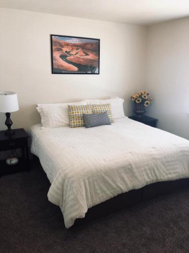a bedroom with a white bed with two pillows at Cedar Canyon Condos in Blanding