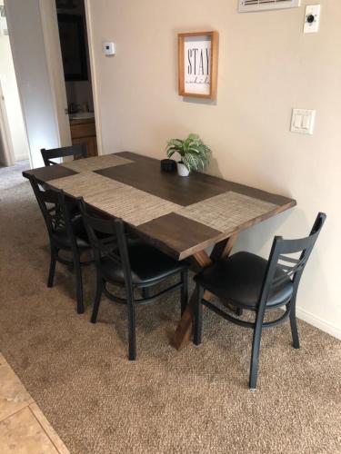 a dining room table with black chairs and a wooden table at Cedar Canyon Condos in Blanding