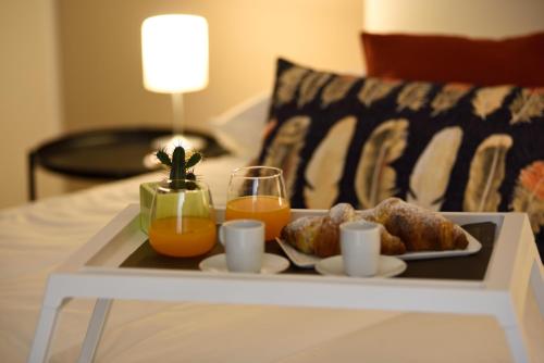 una bandeja de comida en una cama con zumo de naranja en Pyramis Room, en Pontecagnano Faiano