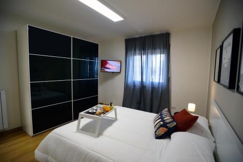 Un dormitorio con una cama blanca y una mesa. en Pyramis Room, en Pontecagnano Faiano