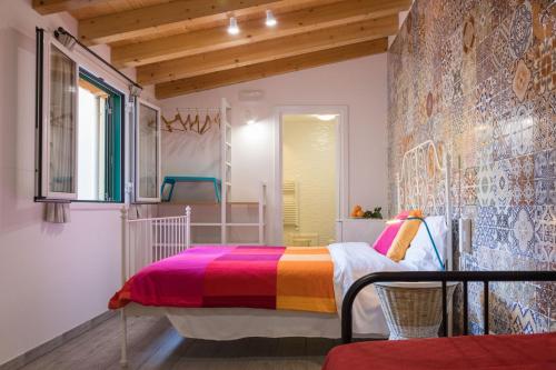 巴勒摩的住宿－Nonna Anna Rooms，一间卧室配有一张带彩色毯子的床
