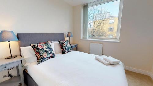 a bedroom with a white bed and a window at NIKSA Serviced Accommodation - Welwyn Garden City Business Park in Welwyn Garden City