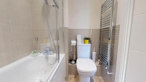 a bathroom with a tub and a toilet and a shower at NIKSA Serviced Accommodation - Welwyn Garden City Business Park in Welwyn Garden City