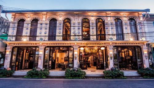 a store front of a building with many windows at สงขลาแต่แรก แอนทีค โฮเท็ล Songkhla Tae Raek Antique Hotel in Songkhla
