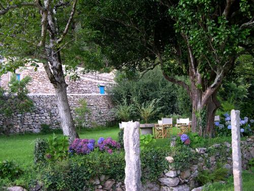 a garden with a table and chairs and flowers at Budiño de Serraseca in Oia