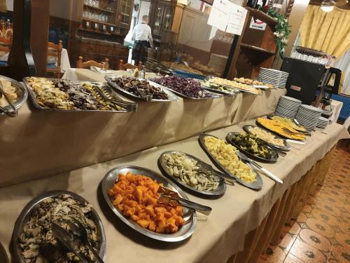 una linea a buffet con molti tipi di cibo diversi di Hotel San Valier a Cavalese