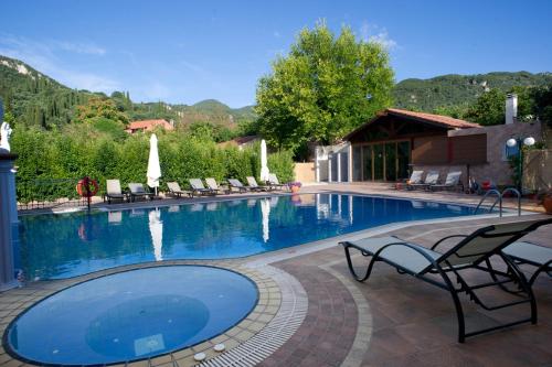 une grande piscine avec des chaises et une table dans l'établissement Apartments Corfu Sun Pool Side, à Benitses