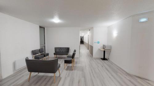 a room with a table and chairs and a hallway at Hôtel du stade ex Kyriad Direct Lille Est Stade Pierre Mauroy in Villeneuve d'Ascq