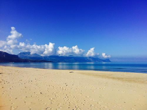 a beach with a view of the ocean and mountains at Elios in Alcamo