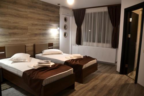 a bedroom with two beds and a window at Pensiune Pavo in Piteşti
