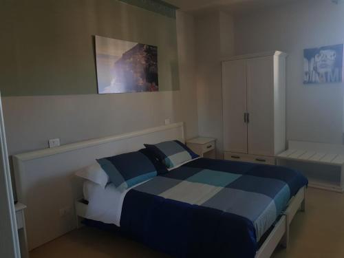 a bedroom with a blue and white bed and a cabinet at B&B La Sicilia a Tavola in Pisa