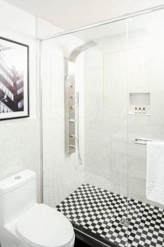 a bathroom with a toilet and a glass shower at Hotel Place D'Armes in Montréal
