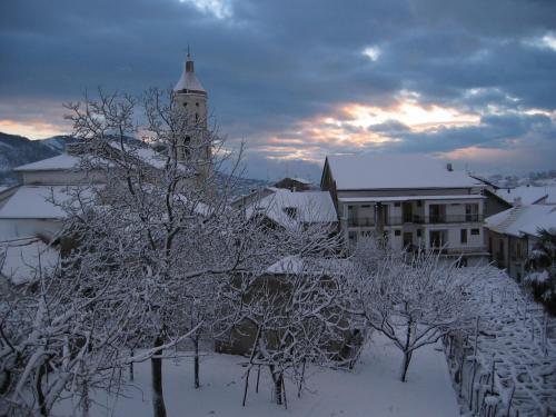a snow covered city with a clock tower in the distance at Hotel Gentile in Agerola