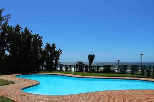 a swimming pool with the ocean in the background at Sands Beach Breaks Luxury Beach Front Ballito in Ballito