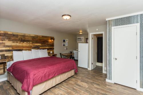 a bedroom with a bed and a wooden wall at Apple Creek Cottages in Prescott