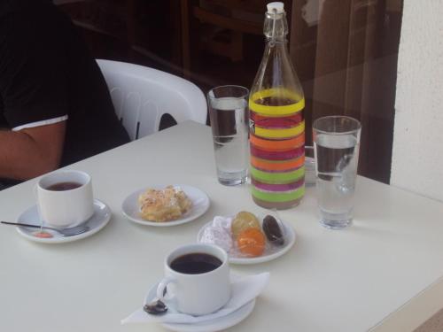a table with a bottle of water and plates of food at Catherine Hotel in Kos Town