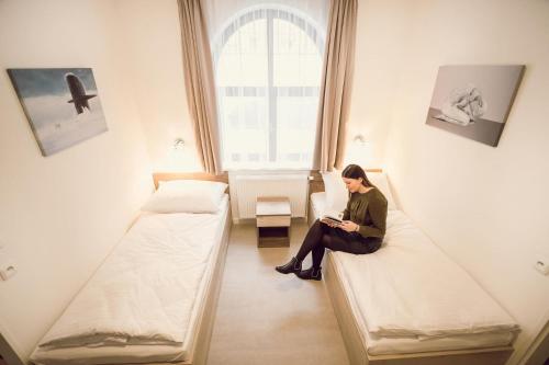 a man sitting on a couch in a room with a laptop at Kings Residence in Prague