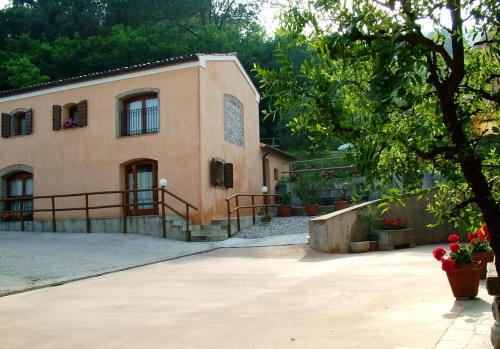 una grande casa con un albero di fronte di agriturismo la scuderia a Galzignano