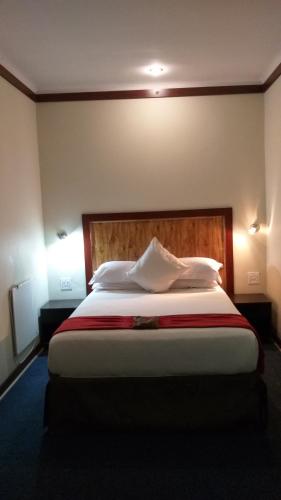 a bedroom with a large bed with a wooden headboard at Road Stay in Maseru