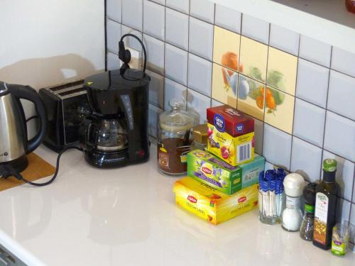 a kitchen counter top with a coffee maker and food at Apartament Kraszewskiego in Bytom