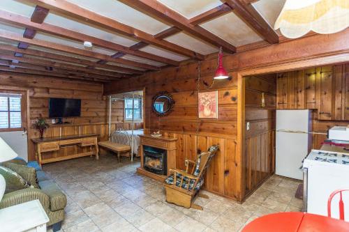 a kitchen and living room with wooden walls and a fireplace at Apple Creek Cottages in Prescott
