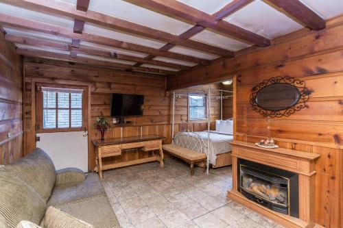 a living room with a fireplace and a bedroom at Apple Creek Cottages in Prescott