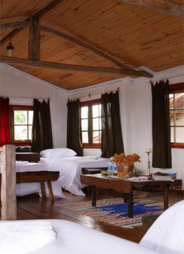 a large room with two beds and a table at Pousada Solar dos Anjos in Lavras Novas