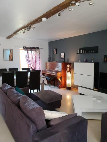 - un salon avec un canapé et un piano dans l'établissement Le verger Fleuri, à Vallières