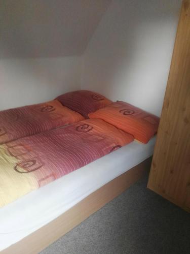 a bed in a room with two orange sheets at Chalupa u Matúšů Jeseníky in Dolní Moravice