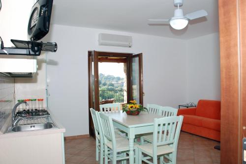 a kitchen with a table and chairs and a couch at Residence Il Casale in Palinuro