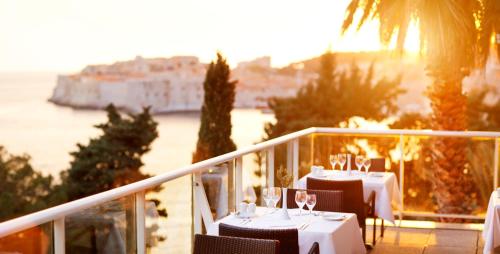 a dining room with a balcony overlooking the ocean at Grand Villa Argentina in Dubrovnik