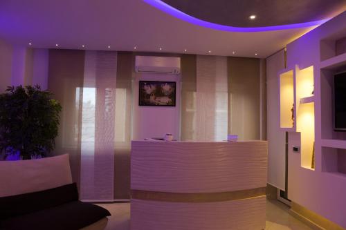 a lobby with a bar with purple lighting at B&B Rossini Luxury in Rende