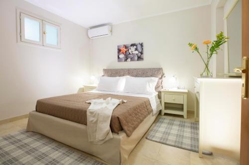 een slaapkamer met een bed in een witte kamer bij Elenas home in Vasiliki