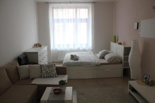 una pequeña sala de estar con cama y sofá en KaVi apartments #2 en Plzeň