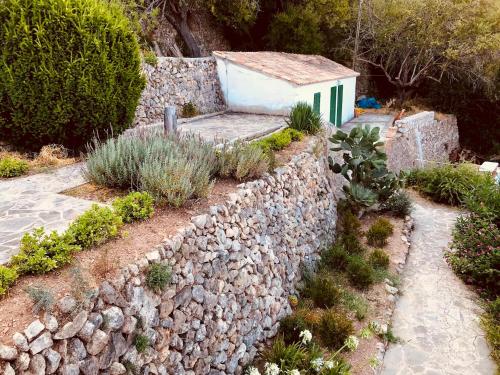 a stone retaining wall with a building in the background at C'an Co Banyalbufar in Banyalbufar