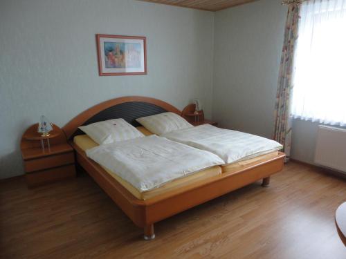 a bedroom with a large bed with a wooden headboard at Zur Kringelwies in Masburg
