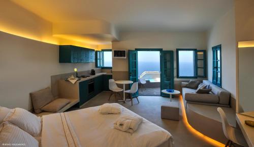 a bedroom with a bed and a kitchen and a living room at Kifines Suites in Chora Folegandros